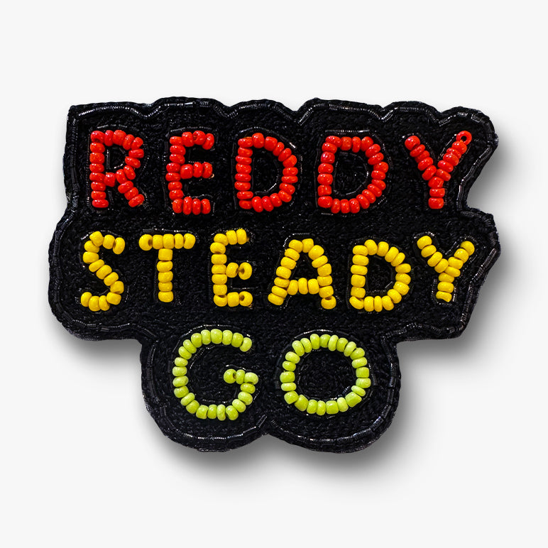 Beaded “READY STEADY GO” text slogan brooch pin in red, yellow and lime on a white background