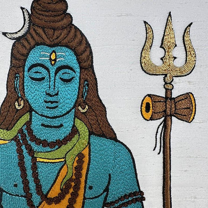 Embroidered detail of a Hindu deity with a trident on a white background