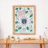 Framed artwork with floral design on a wall above a wooden table.