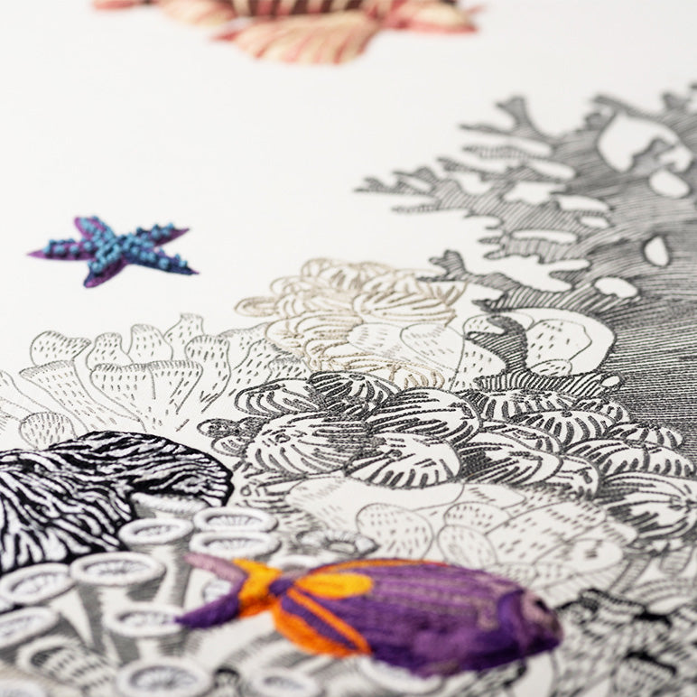 Colorful fish and starfish toys on a black and white coral reef illustration.