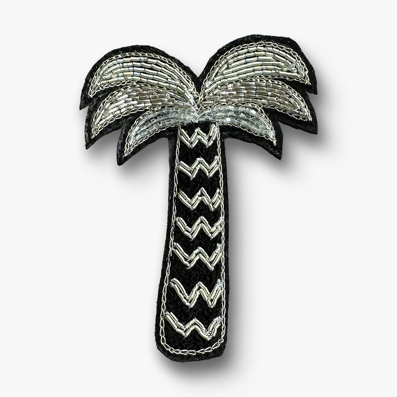 Silver palm tree brooch pin on a white background