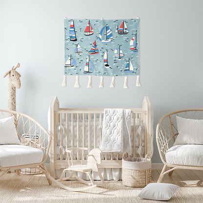 Hand-embroidered sailboat wall hanging of colorful boats on a blue sea—hung above a natural-wood crib in a light, airy nursery.