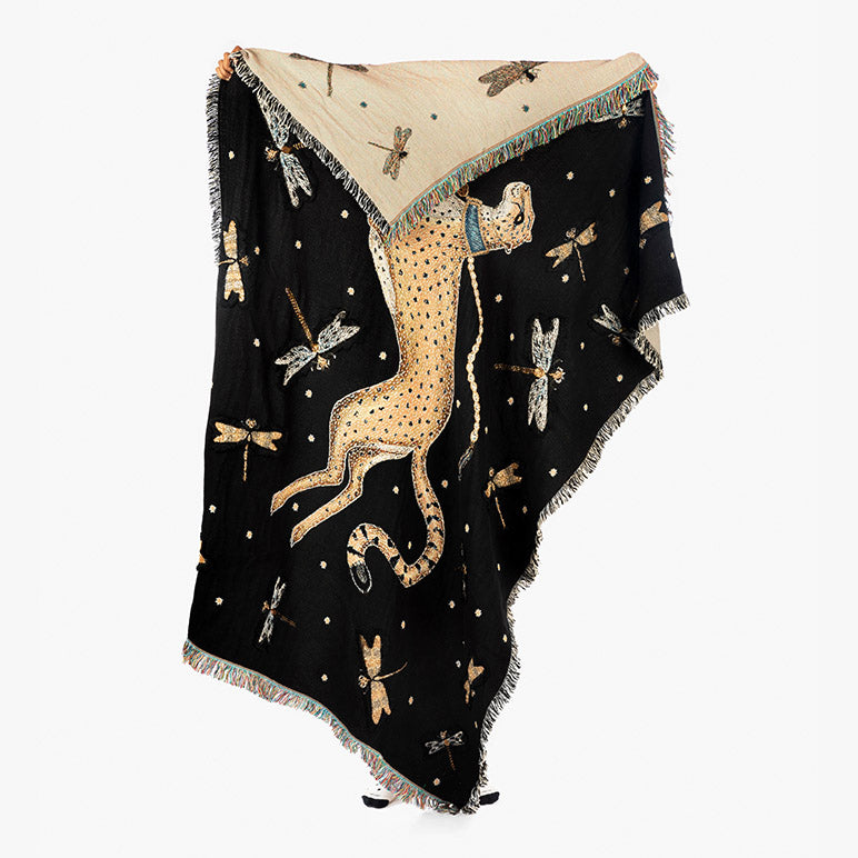 Decorative throw blanket with a leopard and butterfly design on a black background