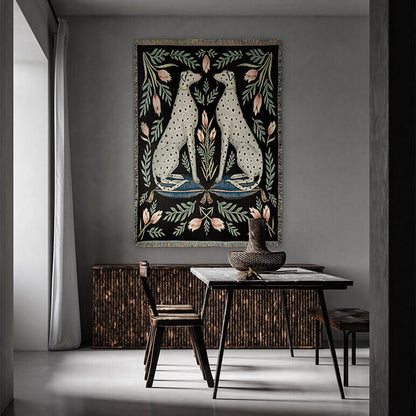 Decorative tapestry with two leopards on a wall above a table in a room.