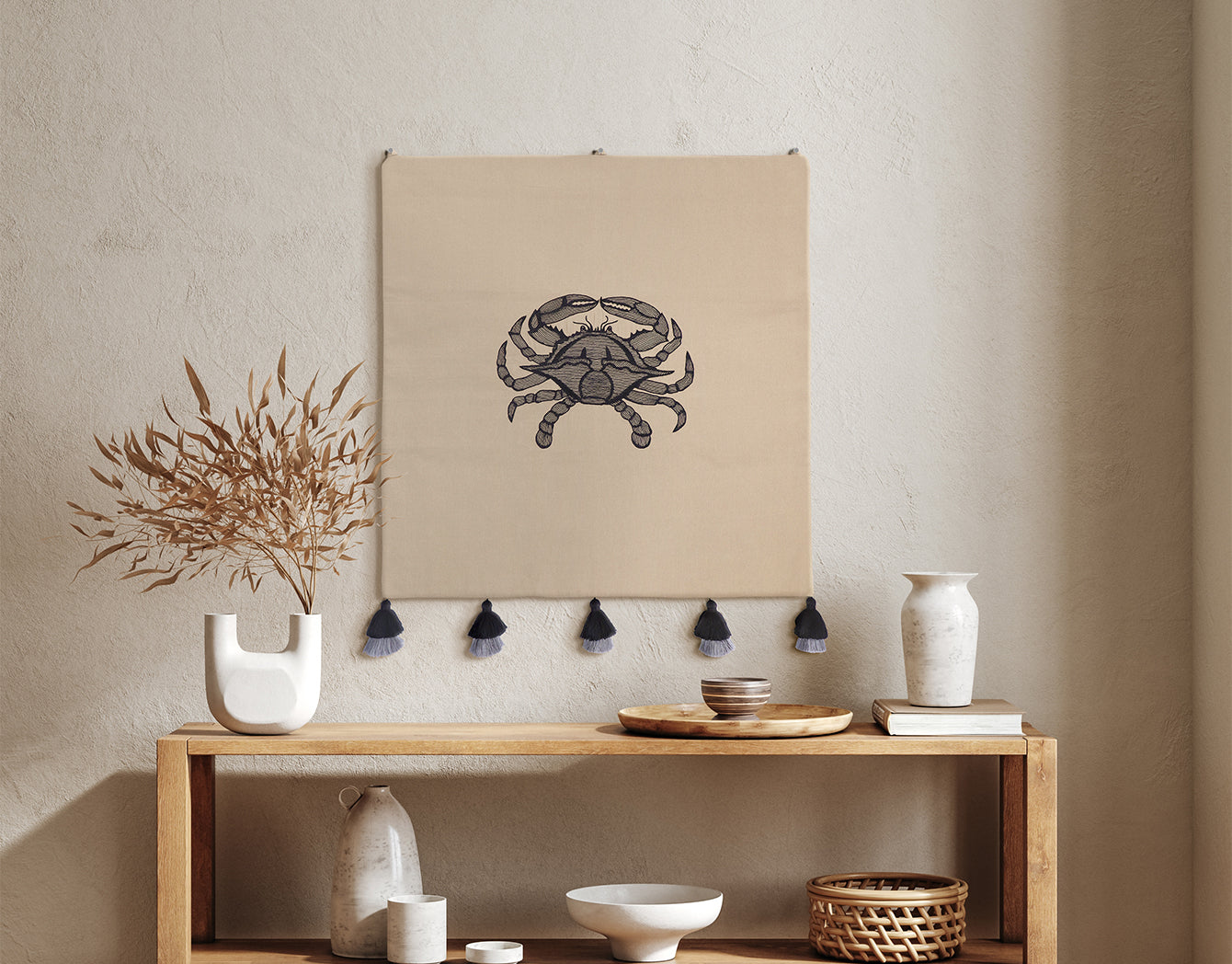 Blue Crab Wall Hanging—embroidered textile wall art on taupe fabric with black tassels—styled above a wooden console; coastal wall decor, handmade crab wall art.