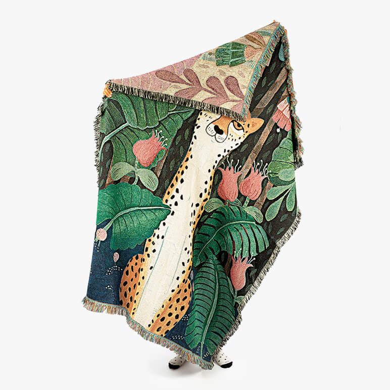Decorative cheetah cotton throw blanket with a cheetah amidst a lush jungle design on a white background