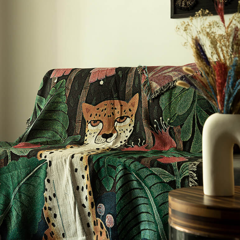 Decorative sofa with a woven throw featuring a cheetah and leaf pattern in a room setting.