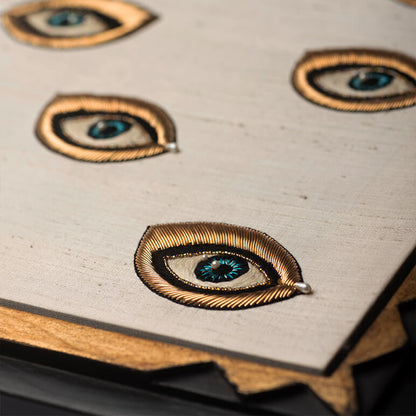 Close-up of decorative eye-shaped pins on a textured surface