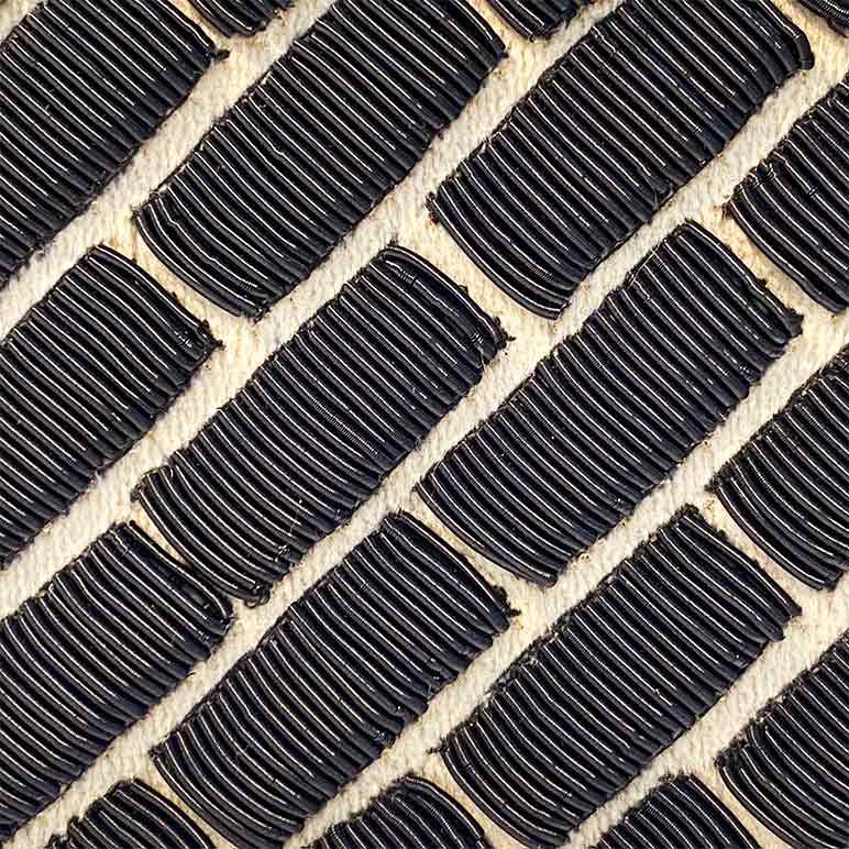 Close-up of black rubber tiles on a beige surface