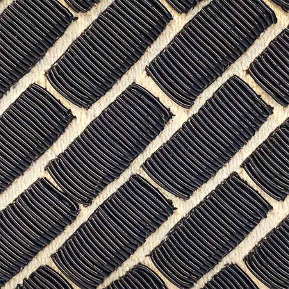 Close-up of black rubber tiles on a beige surface