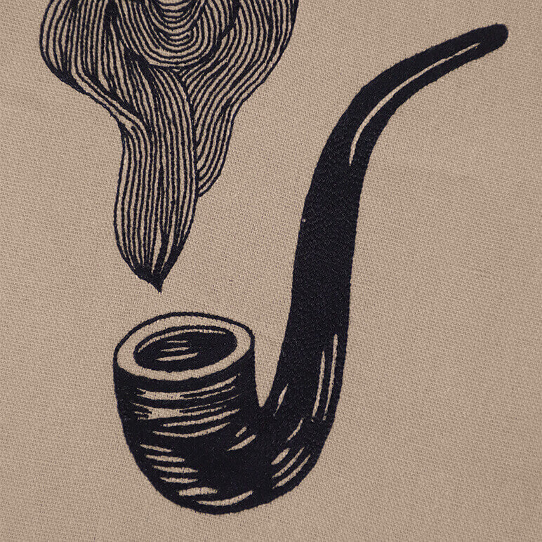 Textile artwork of an embroidered smoking pipe with smoke on a beige background