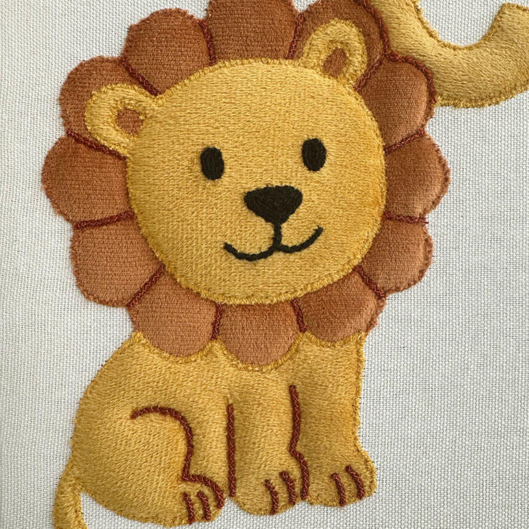 Embroidered patch of a cartoon lion on a light background
