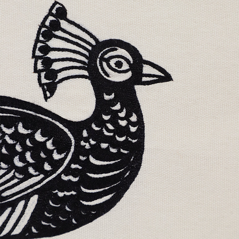 Textile wall hanging of an embroidered Black and white bird design on a beige background