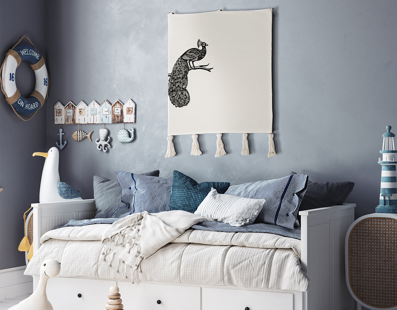 Decorative embroidered wall hanging peacock—black-on-ivory textile wall hanging with tassels—styled above a blue-and-white daybed in a coastal kids’ room; decorative wall hanging/tapestry.
