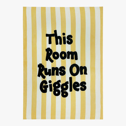 Striped playful nursery wall decor with the text &quot;This Room Runs On Giggles&quot; embroidered on it