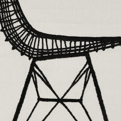 Close-up detail of “Sit Pretty” embroidered wall hanging—black stitched chair lines and geometric base on off-white cotton textile.
