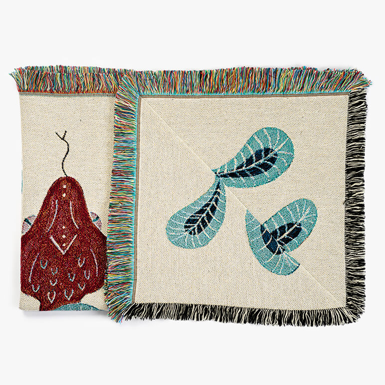 Folded cotton throw blanket with a woven red snake head visible on it