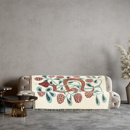 Decorative cotton blanket with a snake design on a sofa against a gray wall.