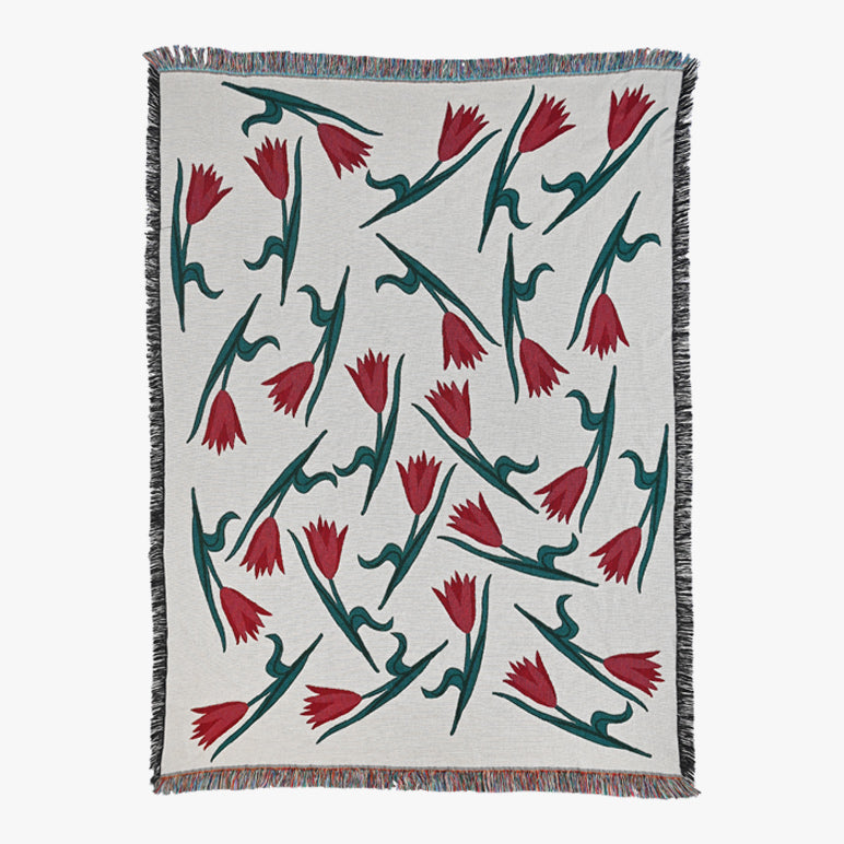 Woven blanket with red and green floral pattern on a white background