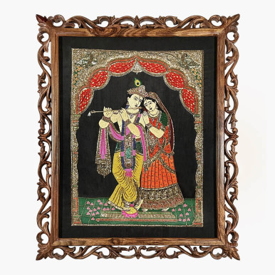 Feature image of a textile artwork showcasing Lord Krishna and Radha, hand beaded in various colours over a black fabric background and framed in a hand carved ornate dark wood frame