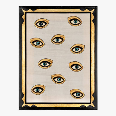 framed white colored wall art featuring a group of blue eyes embroidered in metallic and silk thread 