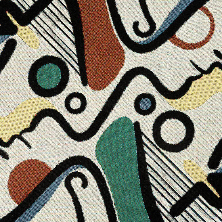 closeup of a woven cotton throw with abstract artwork on top