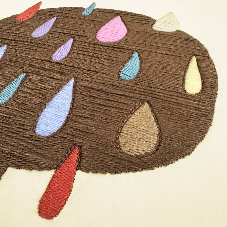 Embroidery details in wool seen in a close up view of an abstract tree wall art