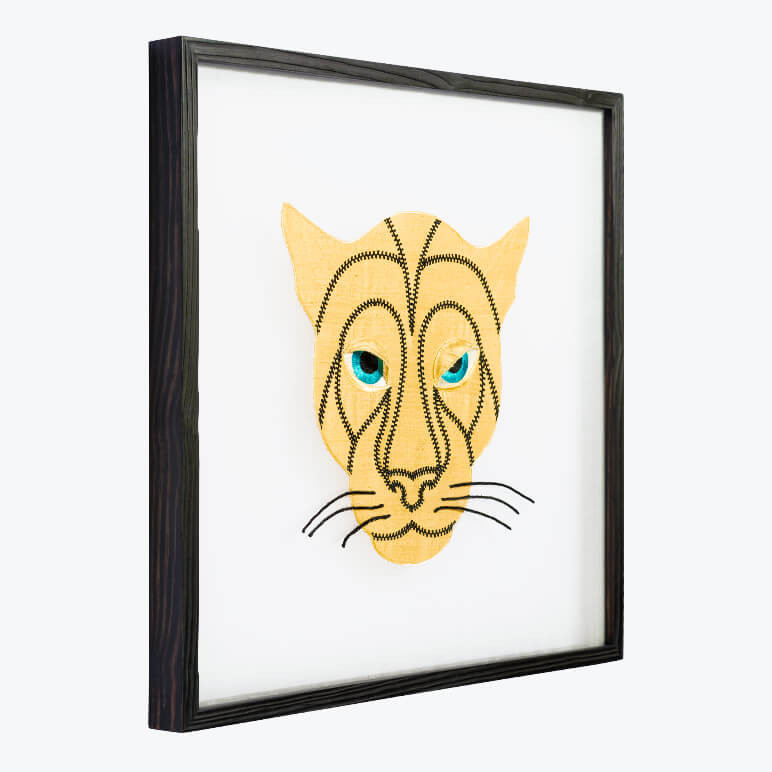 side view of a framed animal wall art featuring a golden panther head with black stitch detailing and whiskers