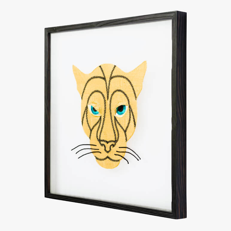 side view of a framed animal wall art featuring a golden panther head with black embroidered detailing
