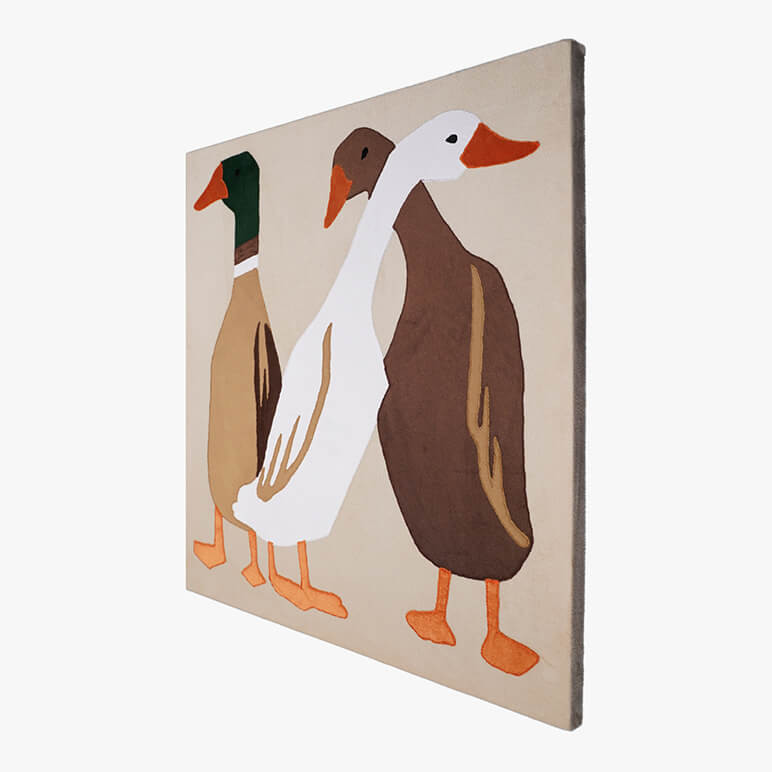Right angle view of a canvas framed animal themed nursery decor piece, featuring three ducks in earthy colors