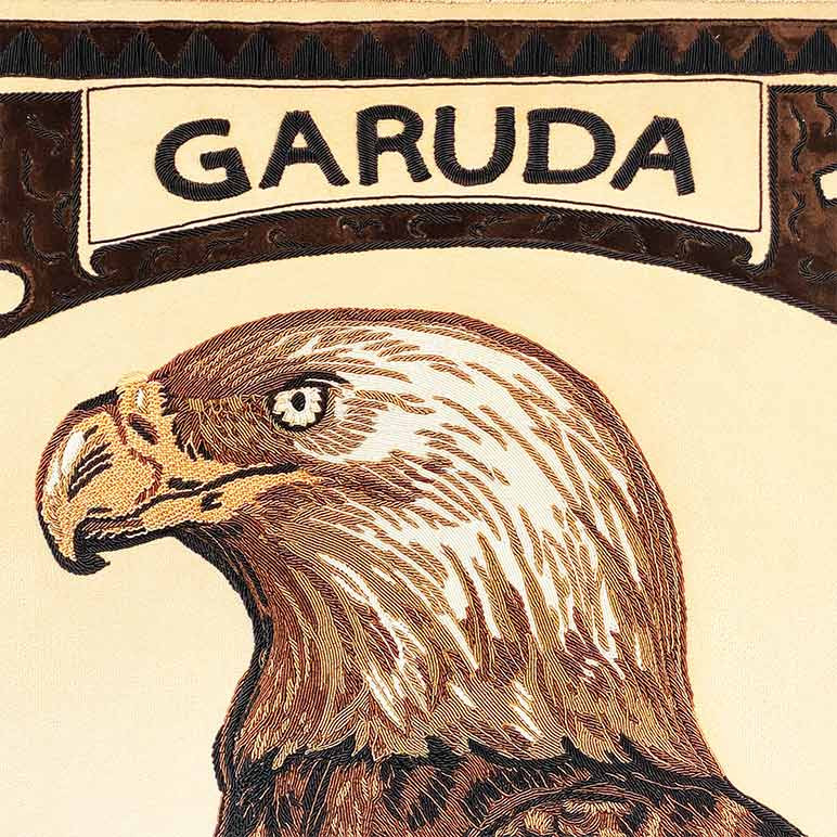 bald eagle art with the name Garuda hand embroidered in French purl wire over an earthy color toned suede fabric