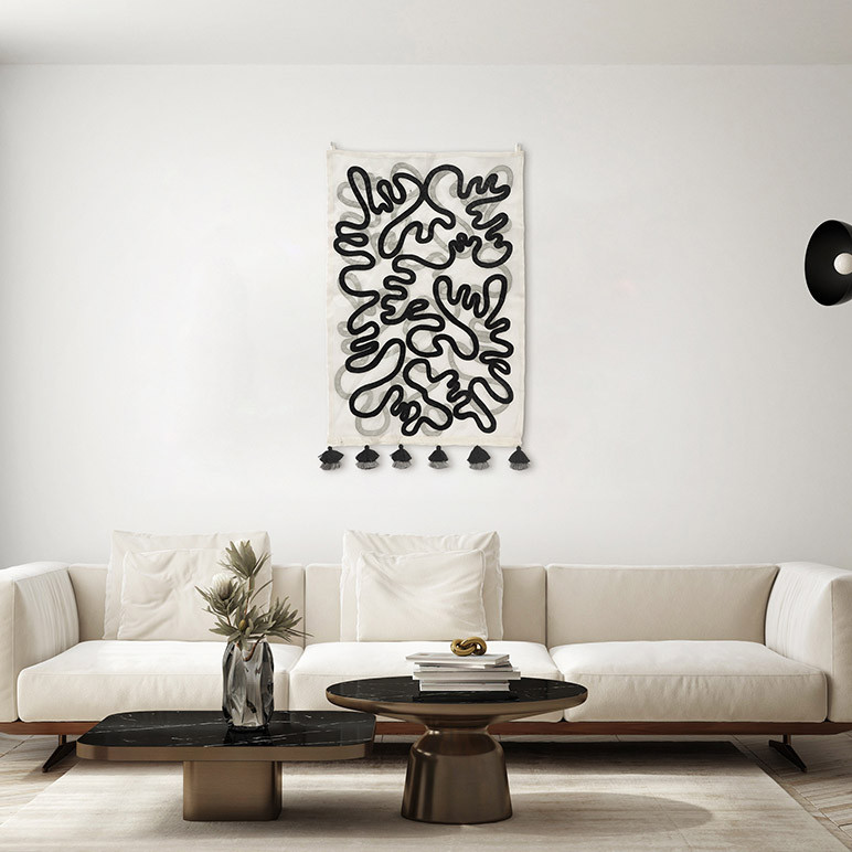 hanging black and white tapestry in a modern white living room