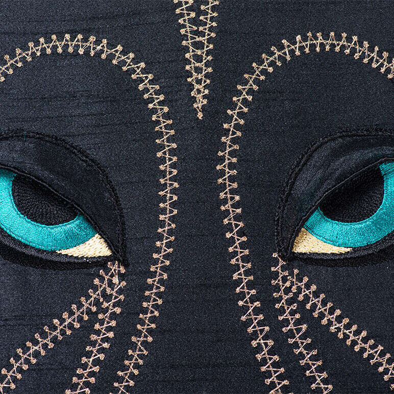 embroidered black panther head done in fabric and thread with blue eyes and gold detailing