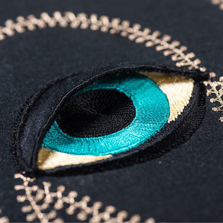embroidered blue eye of a black panther with a black raised eyelid