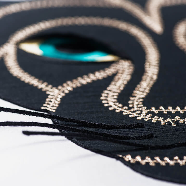 close-up view of the embroidered whiskers on a black panther textile art