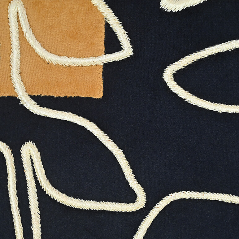 Close up view of embroidery detail on a minimalist textile art, in black and cream colors