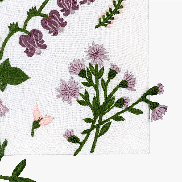 corner detail of a canvas framed 3d botanical textile artwork with stump work florals