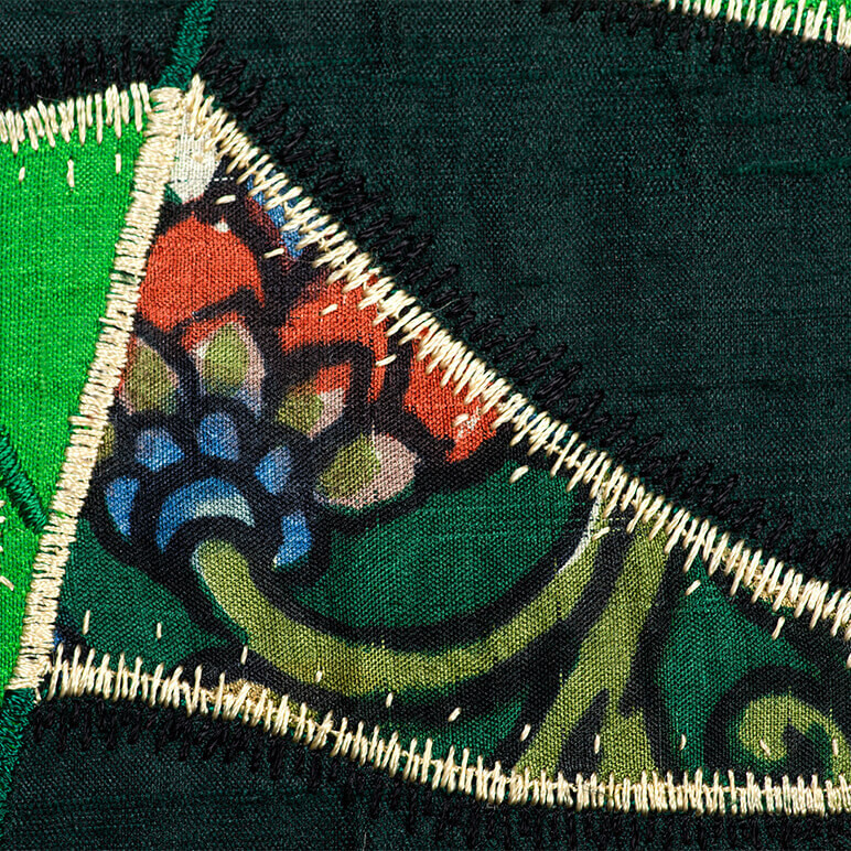 closeup view of the embroidery and patchwork detail on a green cactus wall art