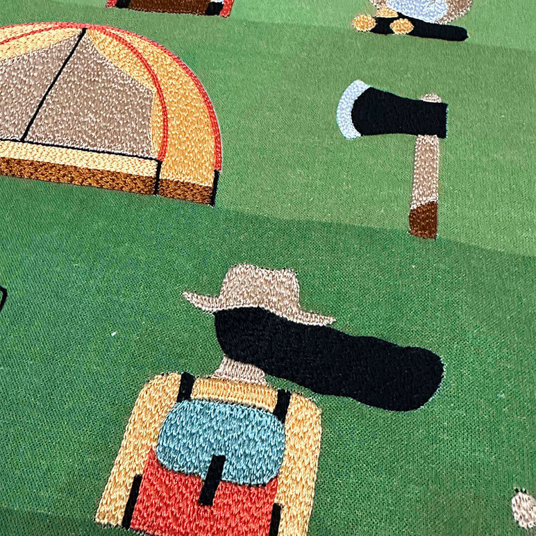 Embroidery detail seen on a cool gift for kids showcasing scenes from camping over a green background