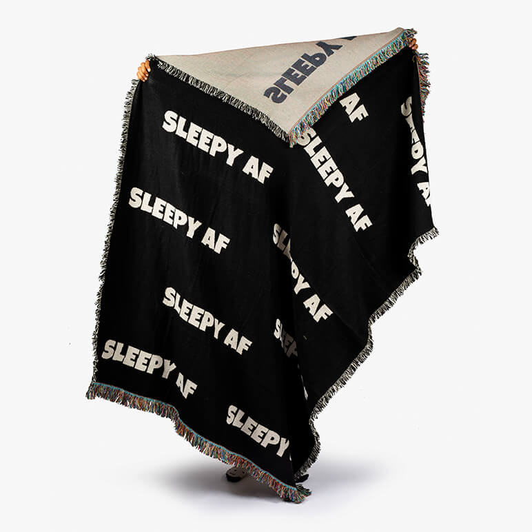black couch throw blanket in black with a typographic print on top in white