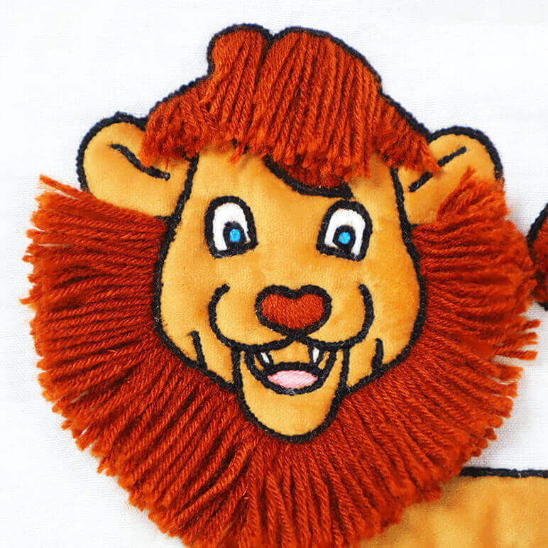 closeup view of an embroidered cute lion with woollen mane