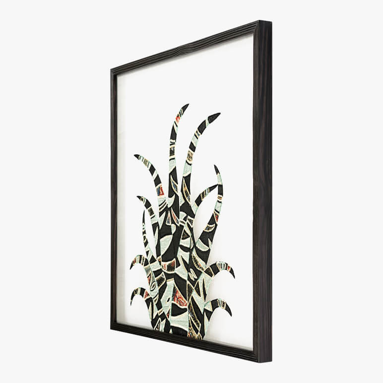 side view of a framed desert themed wall art featuring a black and grey patchworked cactus