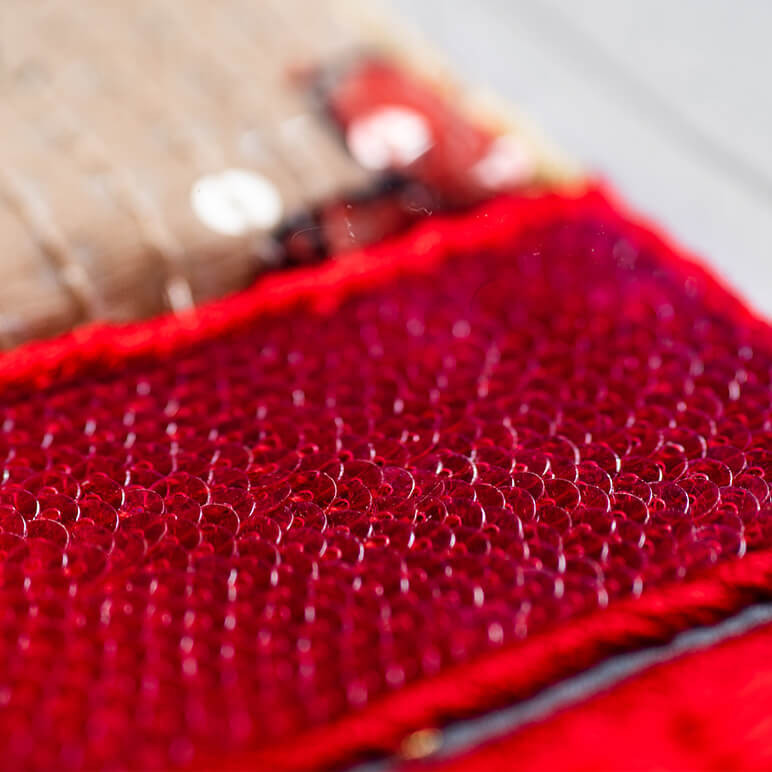 closeup view of the sequin embroidery on a shoe wall art in red color
