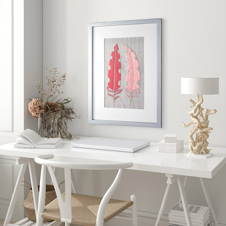 pastel pink feathered textile artwork in a modern farmhouse living room nook with a white table and chair