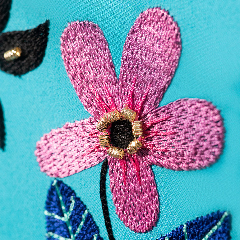 closeup embroidery detail of a pink flower
