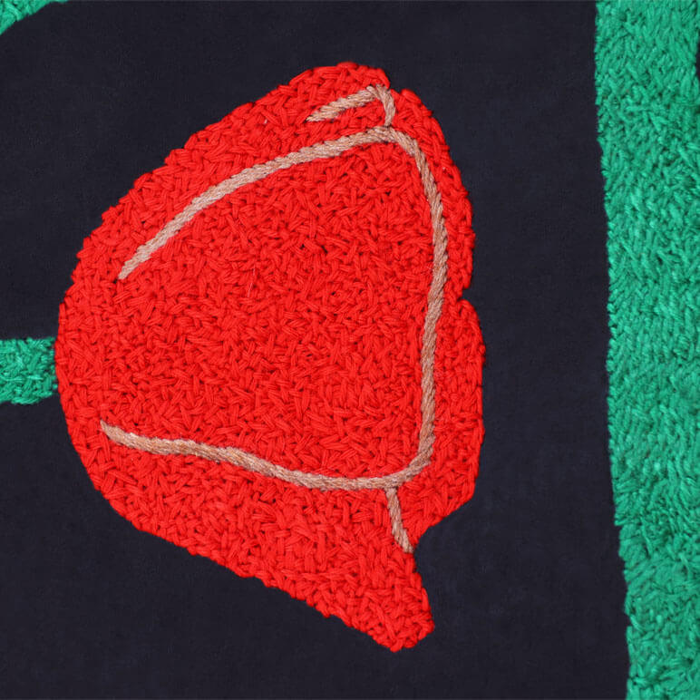 Detailed close up view of a hand-embroidered tulip artwork in black, red and green