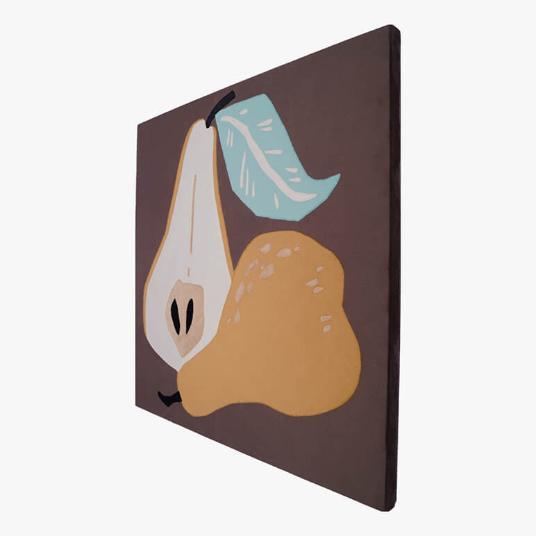 Right angle view of a canvas framed and earthy colored textile artwork featuring a golden pear cut in half