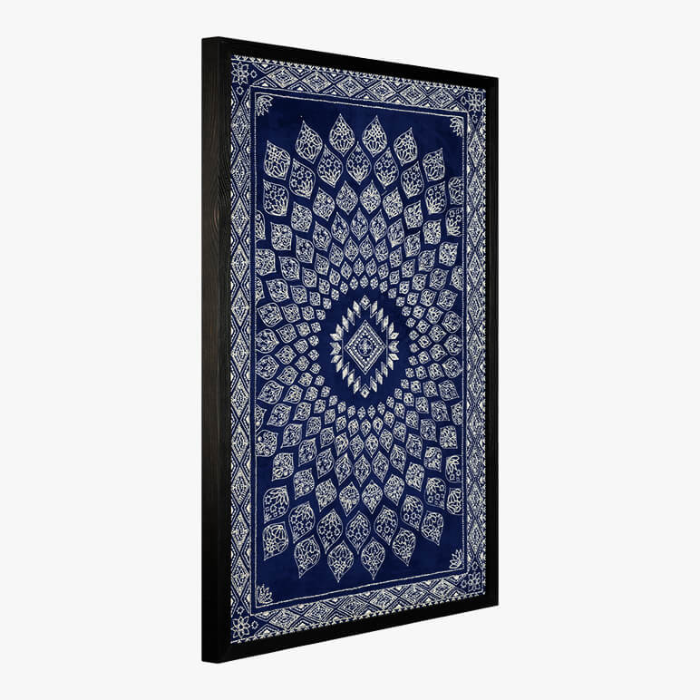 side angle view of a framed tapestry in blue with white embroidery on top
