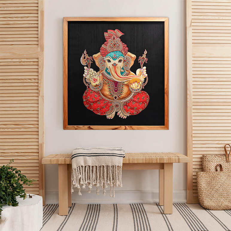 Staged view of a Ganesha painting done in textile art form, seen displayed in an organic modern style of room with plenty of wood accents