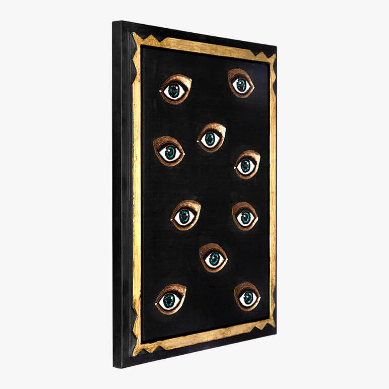 side view of a glam wall décor piece in black and gold featuring a group of blue eyes with copper sequins